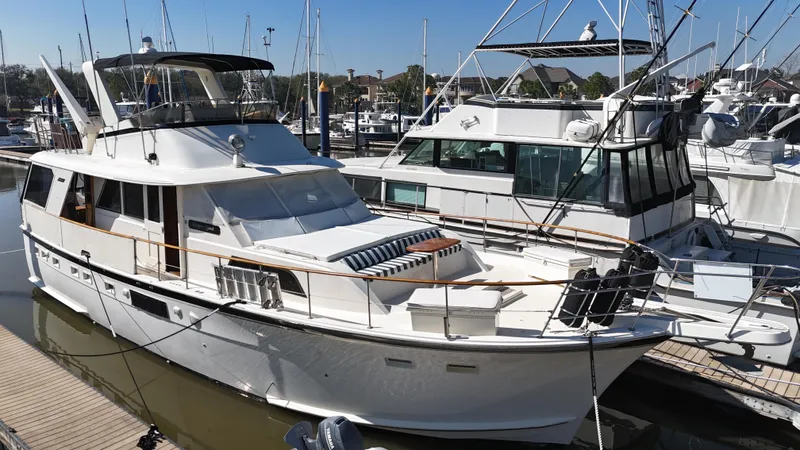 Slide: The Image of 1978 Hatteras 53 Motor Yacht docked at marina, surrounded by other boats. - 8