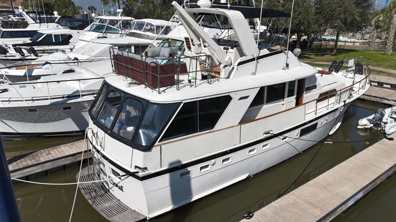 Slide: The Image of 1978 Hatteras 53 Motor Yacht docked in marina, surrounded by other boats. - 9