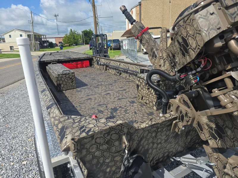 Slide: The Image of 2025 Pro-Drive 1848 SBX boat with camouflage design, parked on a trailer in a residential area. - 12