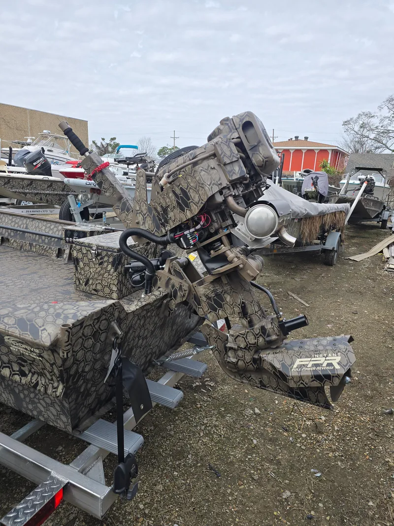 Slide: The Image of 2025 Pro-Drive 1848 SBX boat with camouflage design on a trailer in an outdoor setting. - 6