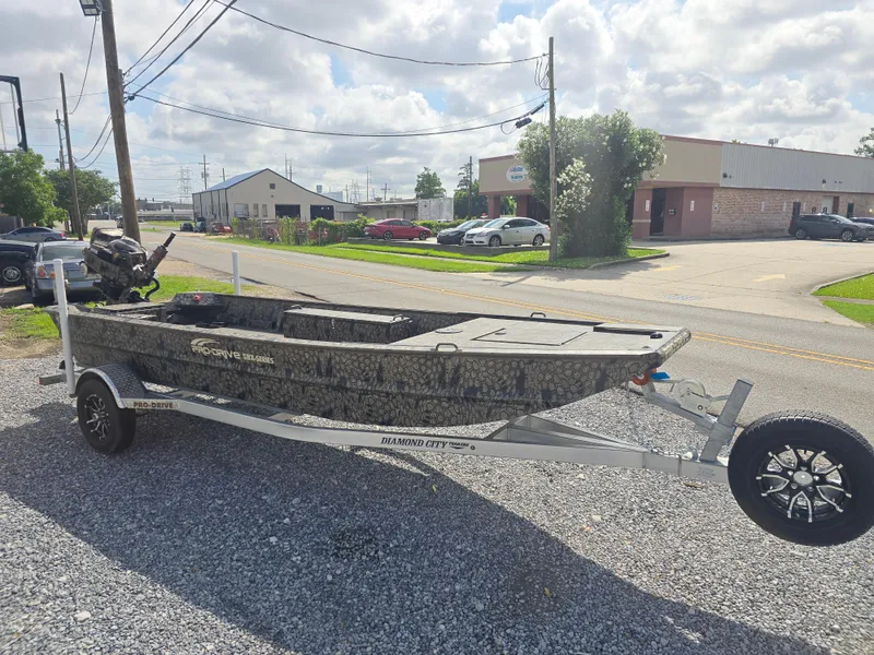 Slide: The Image of 2025 Pro-Drive 1848 SBX boat on trailer, parked outdoors on gravel. - 8