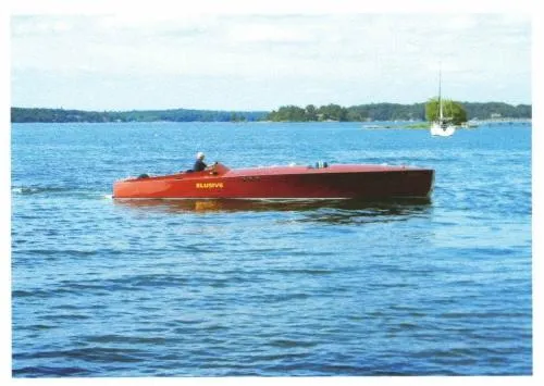 Slide: The Image of Classic 2000 Paul Dewhurst Gentleman's Racer on a serene lake. - 1