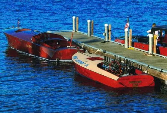 Slide: The Image of Two classic red boats docked on a wooden pier, including a 2000 Paul Dewhurst Gentleman's Racer. - 4