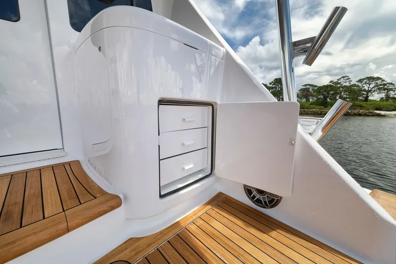 Slide: The Image of 2024 Viking 72 Convertible yacht interior with teak flooring and storage drawers. - 23