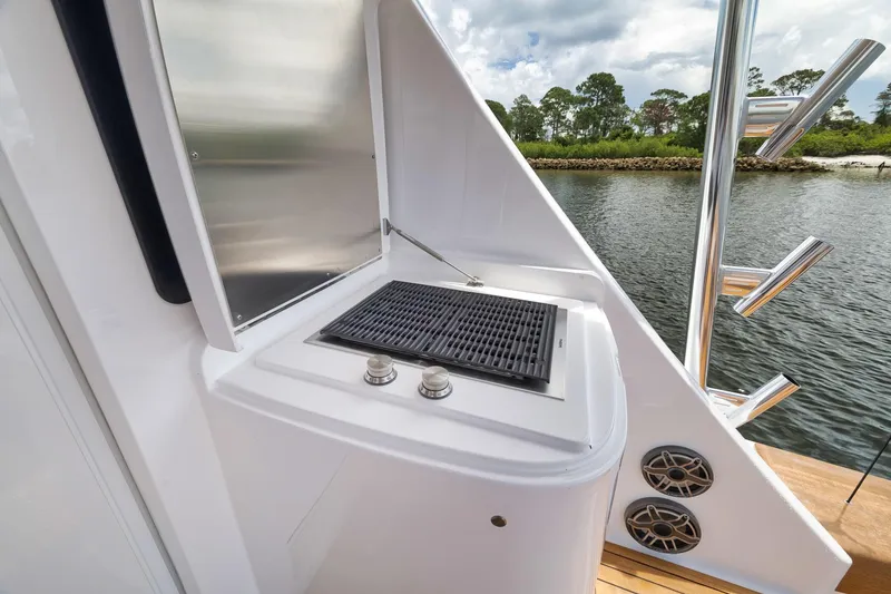 Slide: The Image of Outdoor grill on 2024 Viking 72 Convertible yacht, with scenic water view. - 26