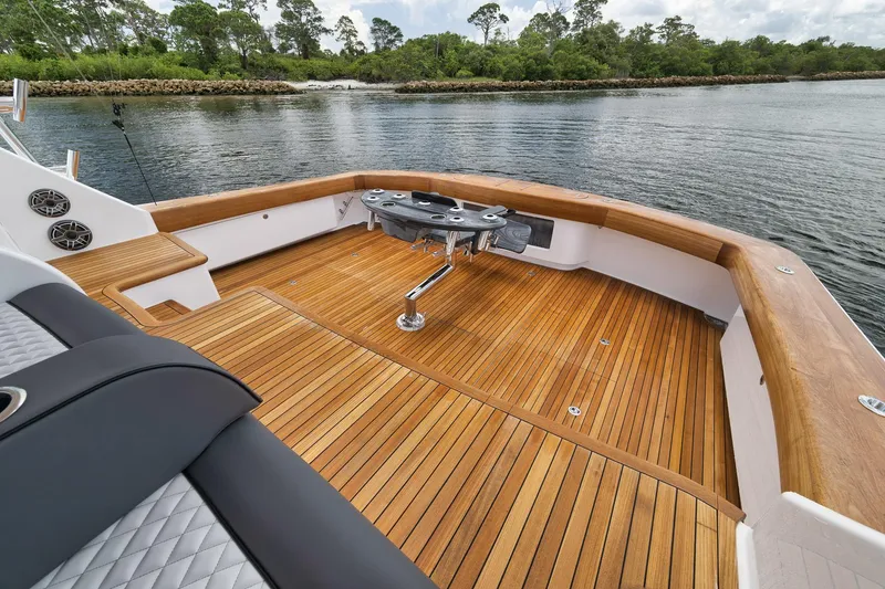 Slide: The Image of 2024 Viking 72 Convertible yacht with teak deck, fishing rod holders, and scenic water view. - 33