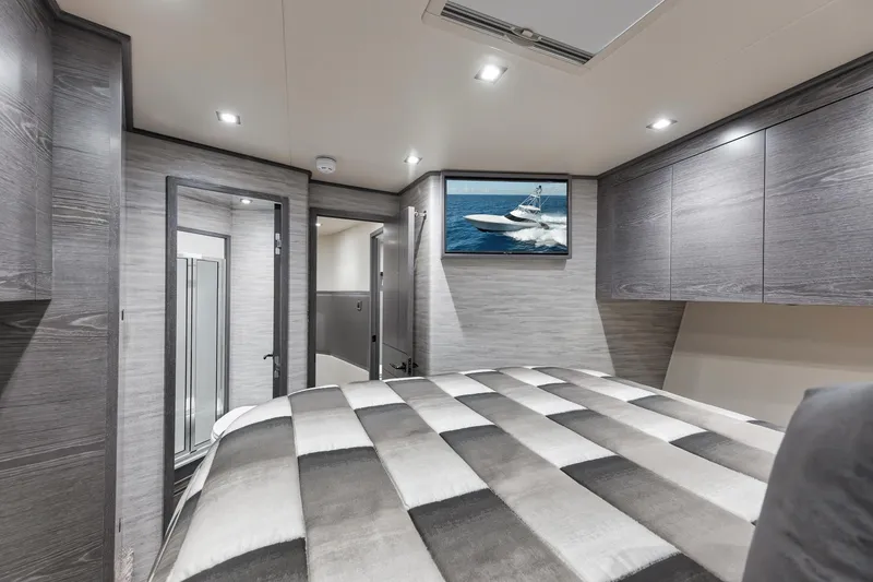 Slide: The Image of Luxurious 2024 Viking 72 Convertible yacht bedroom with modern decor and TV. - 48