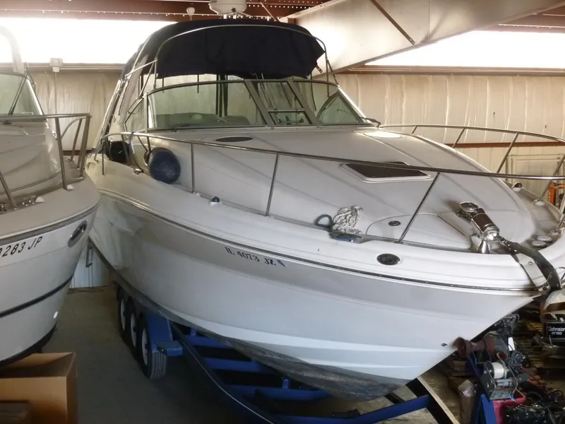 The Image of 2005 Sea Ray 320 Sundancer boat in storage, on a trailer, indoors. - 0