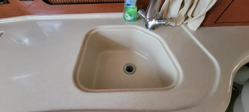 Slide: The Image of 2005 Sea Ray 320 Sundancer kitchen sink with faucet and soap bottle. - 19