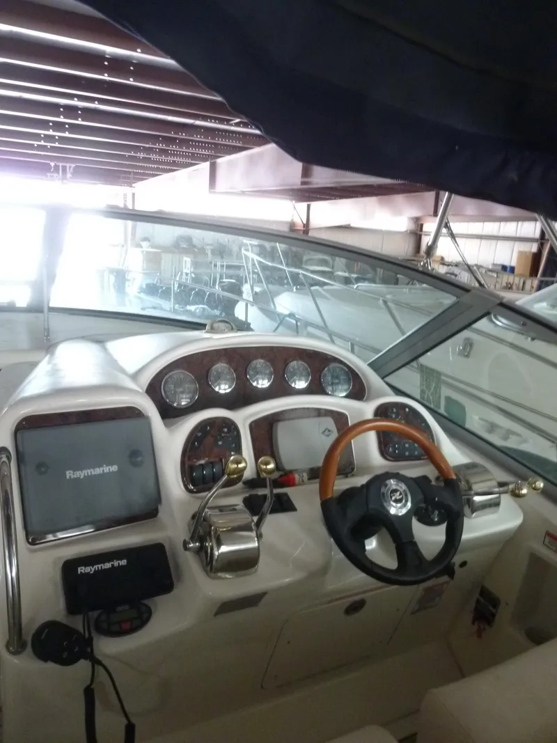 Slide: The Image of 2005 Sea Ray 320 Sundancer helm with steering wheel and navigation instruments. - 28