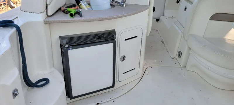 Slide: The Image of 2005 Sea Ray 320 Sundancer interior with mini fridge and storage compartments. - 5