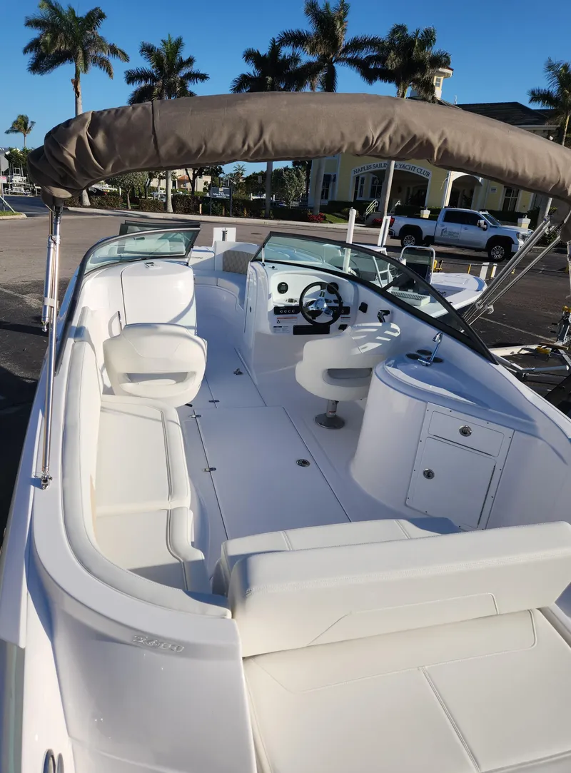 Slide: The Image of 2025 SouthWind 2600 SD boat with spacious seating and canopy, docked under clear skies. - 8