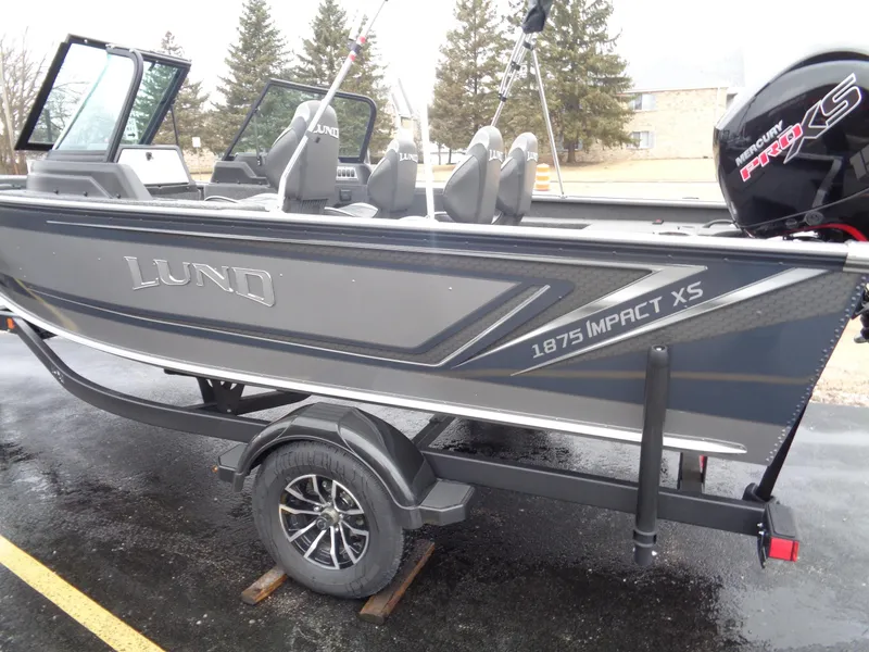 Slide: The Image of 2025 Lund 1875 Impact XS Sport boat on trailer, parked outdoors. - 10