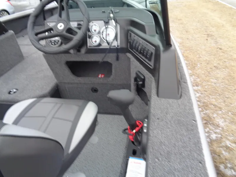 Slide: The Image of 2025 Lund 1875 Impact XS Sport boat interior with steering wheel and control panel. - 12