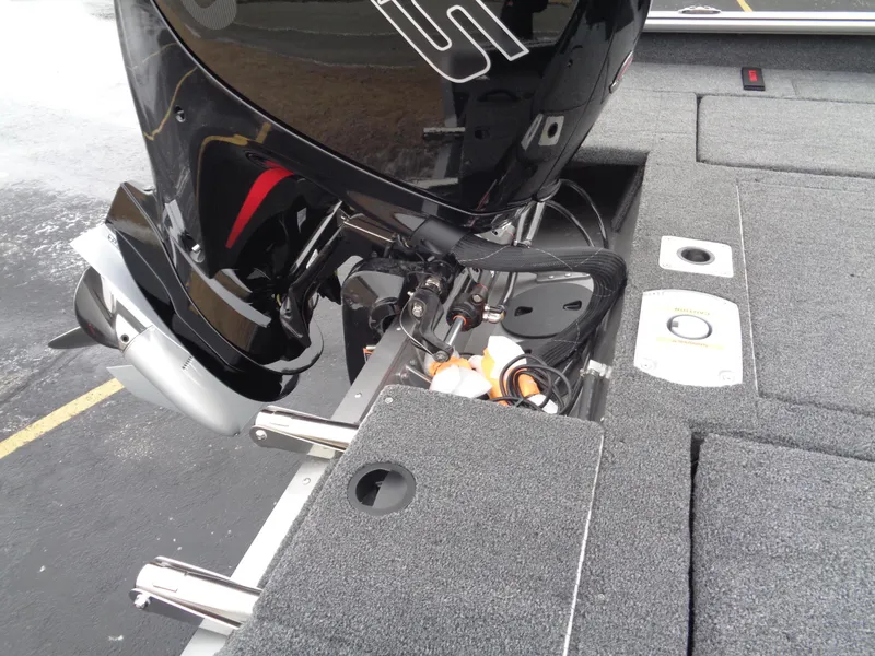 Slide: The Image of 2025 Lund 1875 Impact XS Sport boat, featuring a sleek black motor and gray carpeted deck. - 13