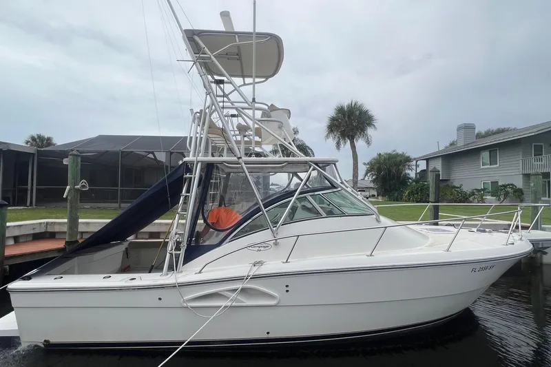 The Image of 2006 Rampage 30 Offshore boat docked near waterfront homes, featuring a sleek design and tower. - 0