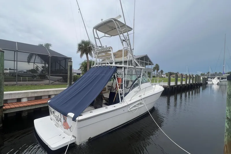 Slide: The Image of 2006 Rampage 30 Offshore boat docked with blue canopy and fishing tower. - 1