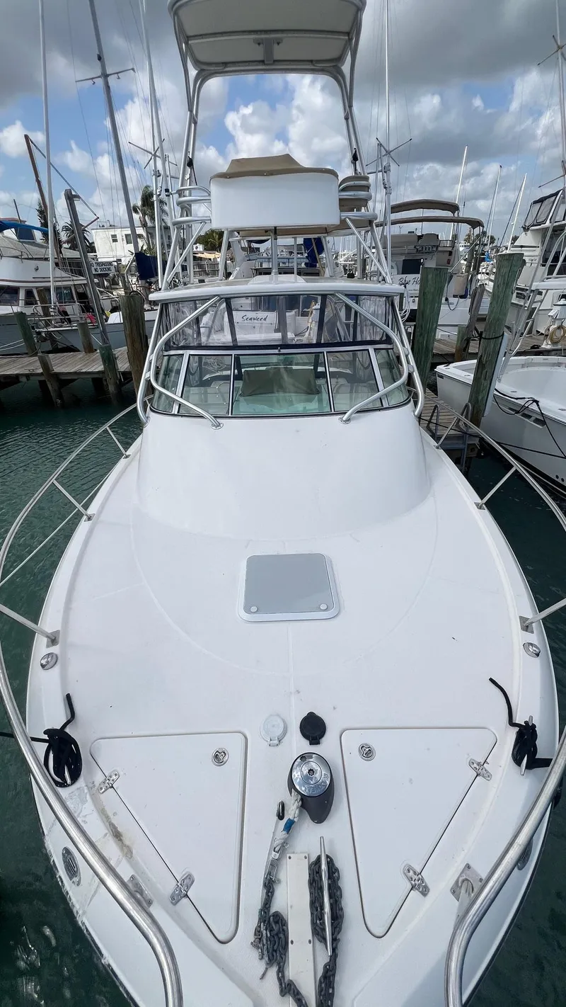 Slide: The Image of 2006 Rampage 30 Offshore boat docked at a marina under cloudy skies. - 12