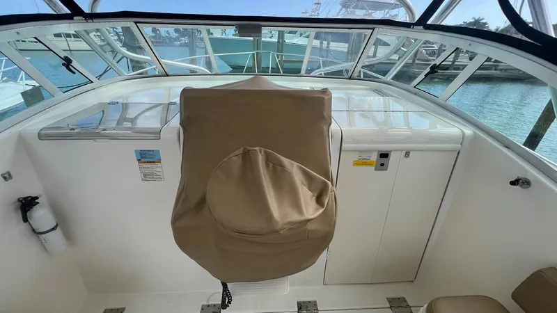 Slide: The Image of 2006 Rampage 30 Offshore boat helm with covered captain's chair and clear windshield. - 14