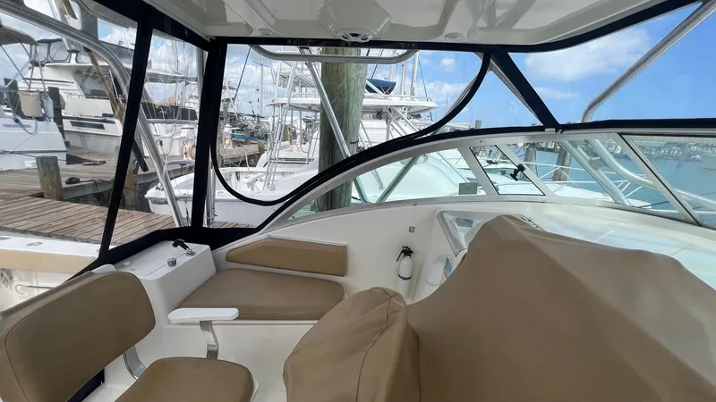 Slide: The Image of Interior view of 2006 Rampage 30 Offshore boat with seating and marina background. - 18