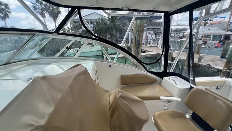 Slide: The Image of 2006 Rampage 30 Offshore boat interior with beige seating and marina view. - 19