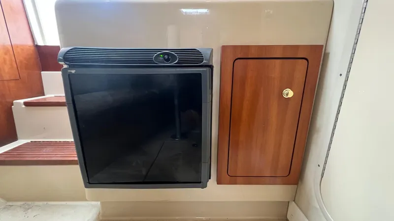 Slide: The Image of 2006 Rampage 30 Offshore interior with fridge and wooden cabinet. - 38