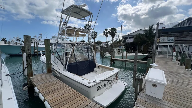 Slide: The Image of 2006 Rampage 30 Offshore boat docked at a marina under a partly cloudy sky. - 5