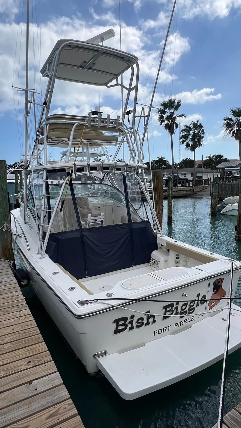 Slide: The Image of 2006 Rampage 30 Offshore boat docked, featuring a tower and clear skies. - 6