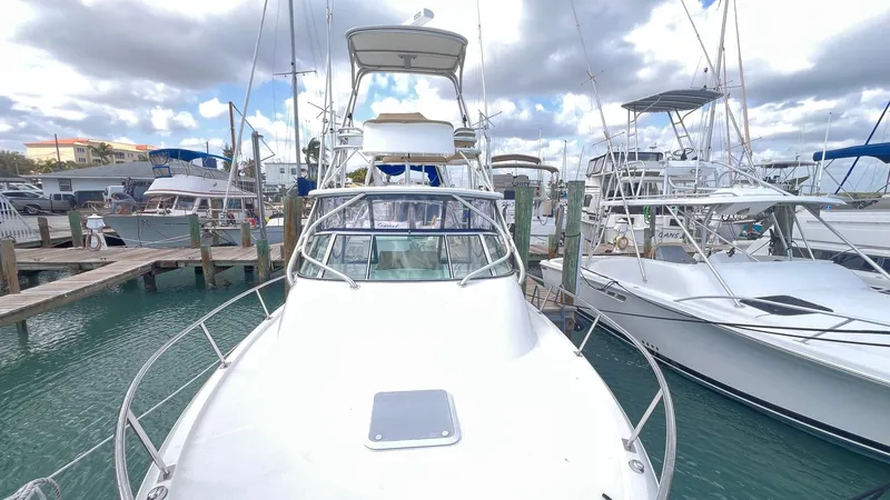 Slide: The Image of 2006 Rampage 30 Offshore boat docked at marina, surrounded by other vessels. - 8