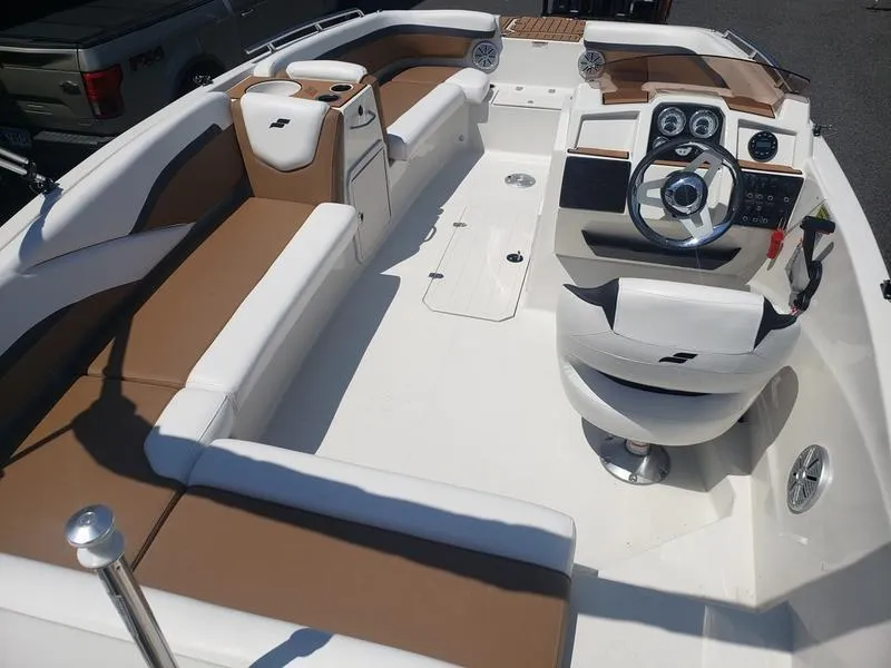 Slide: The Image of 2023 Starcraft SVX 191 OB boat interior with brown and white seating, steering console, and controls. - 19