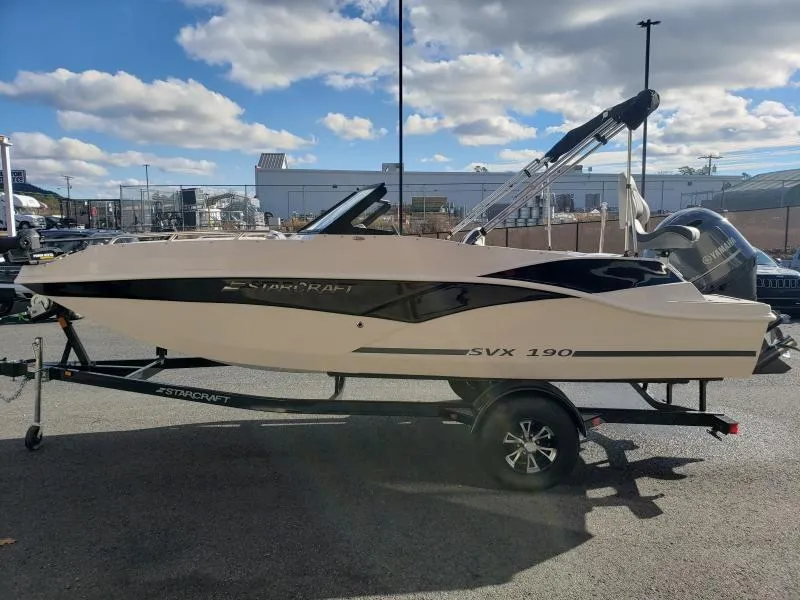 Slide: The Image of 2024 Starcraft SVX 190 OB boat on trailer, parked outdoors under a partly cloudy sky. - 3