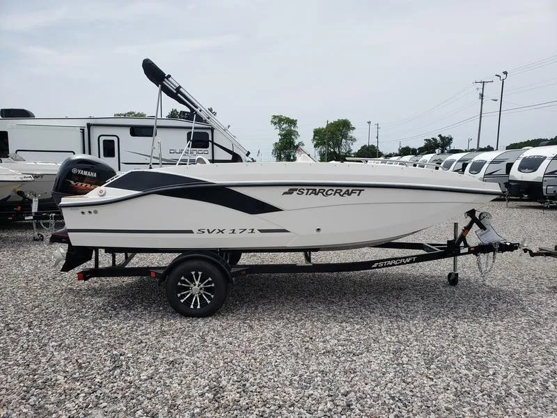 Slide: The Image of 2023 Starcraft SVX 171 OB boat on trailer, parked on gravel lot. - 10