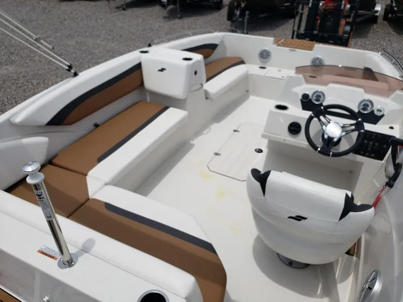 Slide: The Image of 2023 Starcraft SVX 171 OB boat interior with brown and white seating, steering wheel, and dashboard. - 11