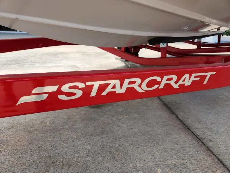 Slide: The Image of 2024 Starcraft SVX 171 OB boat trailer with red frame on concrete surface. - 13