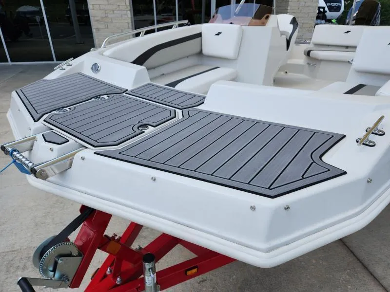 Slide: The Image of 2024 Starcraft SVX 171 OB boat with sleek deck design on a red trailer. - 17