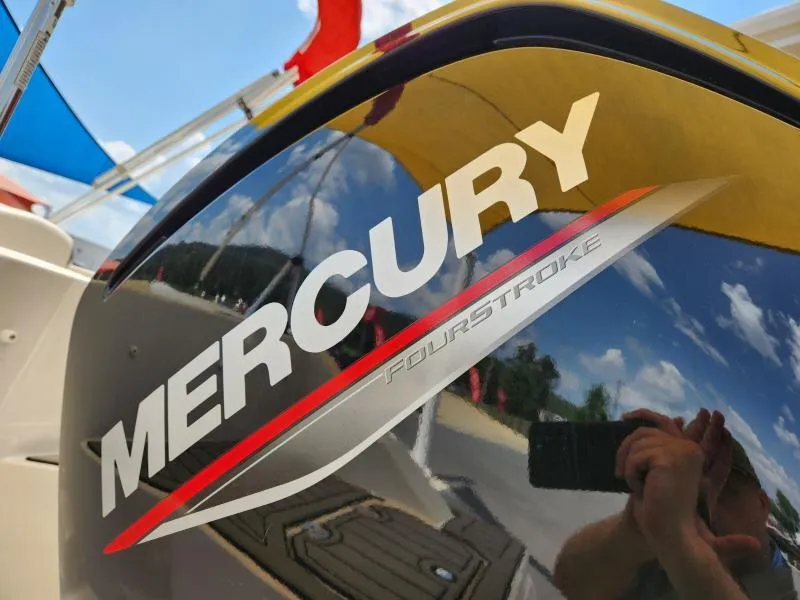 Slide: The Image of Mercury FourStroke engine on 2024 Starcraft SVX 171 OB boat, reflecting sky and surroundings. - 8