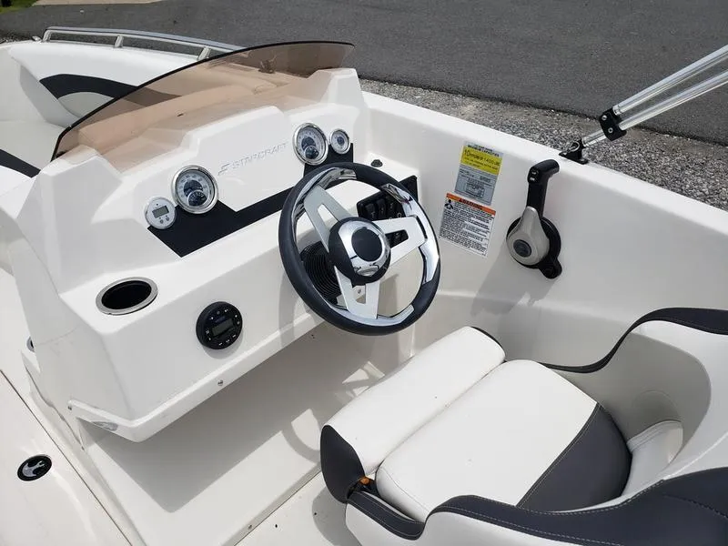 Slide: The Image of 2023 Starcraft SVX 171 OB boat cockpit with steering wheel and dashboard controls. - 10