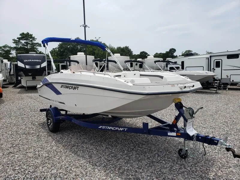 Slide: The Image of 2023 Starcraft SVX 171 OB boat on trailer, parked in a lot with RVs. - 17