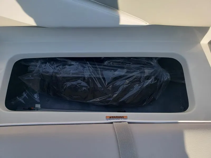 Slide: The Image of Storage compartment in 2023 Starcraft SVX191OB boat, featuring a warning label. - 14