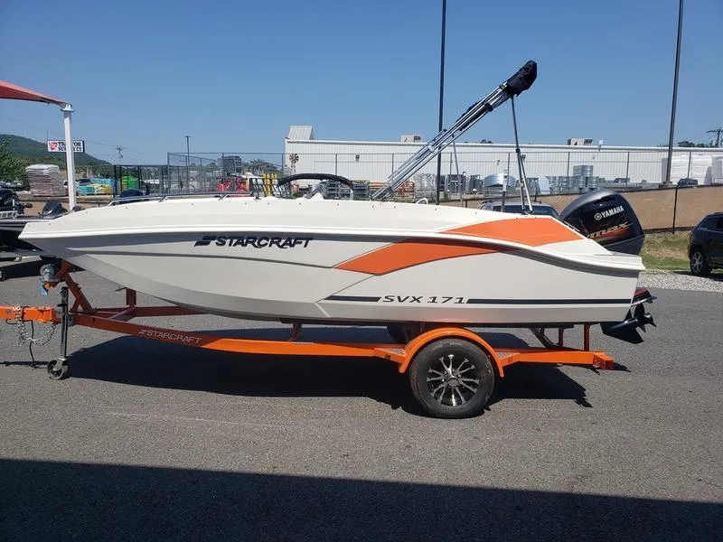 Slide: The Image of 2023 Starcraft SVX 171 OB boat on orange trailer, parked outdoors. - 3