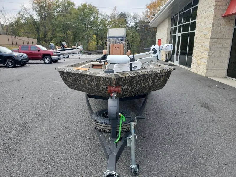 Slide: The Image of 2024 Avid Rogue 20 CC boat on trailer, camo design, parked outside dealership. - 5