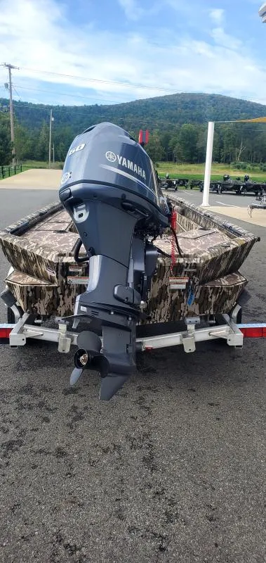 Slide: The Image of 2025 Avid 16 Commander boat with Yamaha motor on trailer, camo design, outdoor setting. - 5