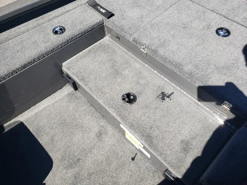 Slide: The Image of Interior of 2023 Avid 18XC boat with carpeted flooring and storage compartments. - 16