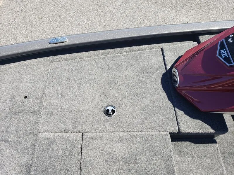 Slide: The Image of Avid 18XC 2023 boat deck with carpet and red motor cover. - 18