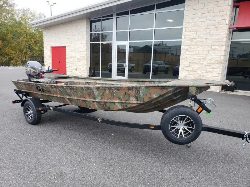 Slide: The Image of 2024 G3 Sportsman 1610 boat with camouflage design on a trailer, parked outside a building. - 2