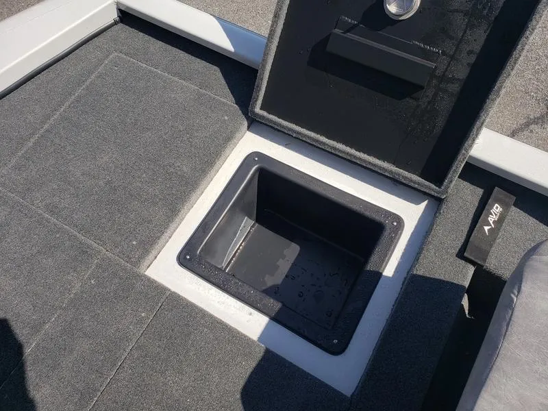 Slide: The Image of Open storage compartment on 2023 Avid 18XB boat with gray carpeted flooring. - 10