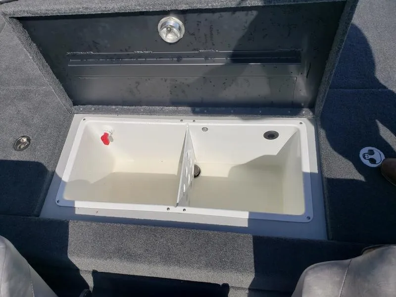 Slide: The Image of Open storage compartment on 2023 Avid 18XB boat, featuring a divided interior. - 9