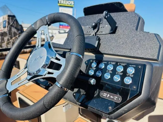 Slide: The Image of Steering console of 2024 Avid 19XB boat with control panel and steering wheel. - 14