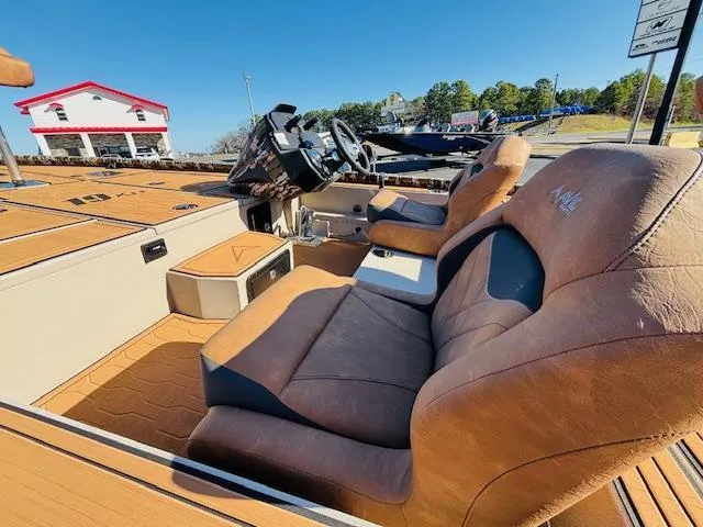 Slide: The Image of 2024 Avid 19XB boat interior with brown leather seats and modern dashboard. - 21