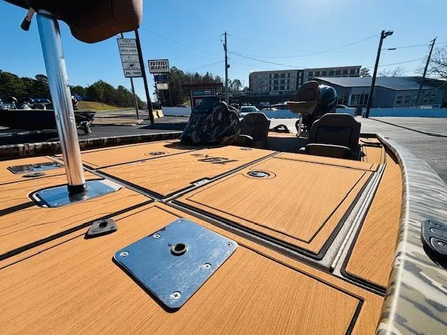 Slide: The Image of 2024 Avid 19XB boat deck with storage compartments in a marina setting. - 22